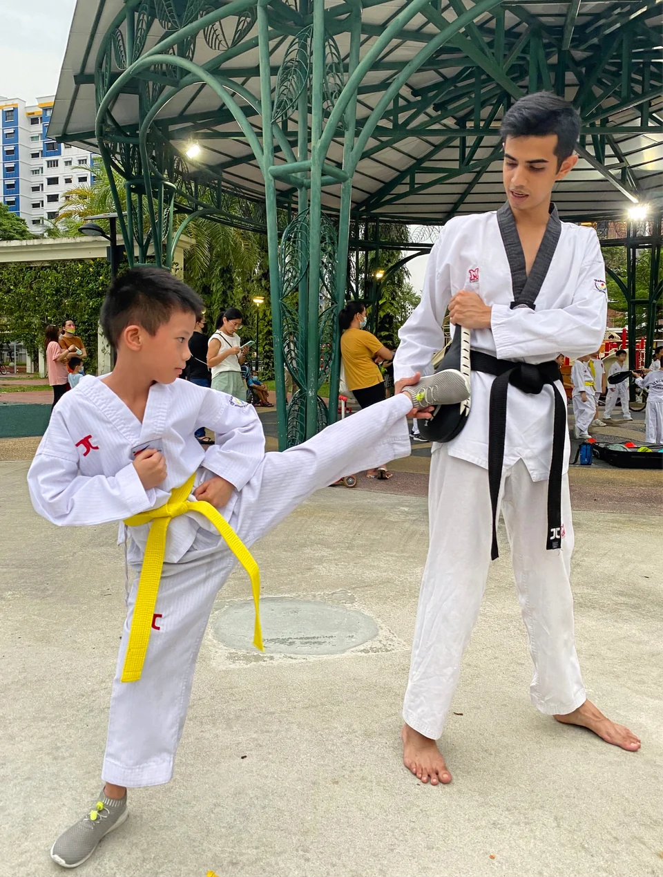 Singapore Taekwondo Federation coach teaching his student how to do the side kick